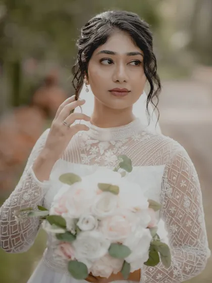 A classic portrait of a Christian bride holding her bouquet, looking away thoughtfully.