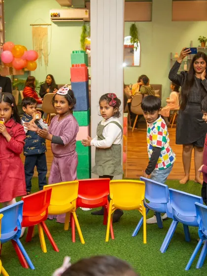 Kids and parents alike watch the game of musical chairs unfold. The shared excitement brings everyone together.