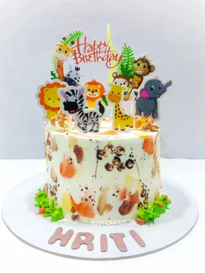 This simple animal theme cake features a unique hand-painted texture on the whipped cream. The cute animal toppers make it a fun and artistic centerpiece for a child's birthday.