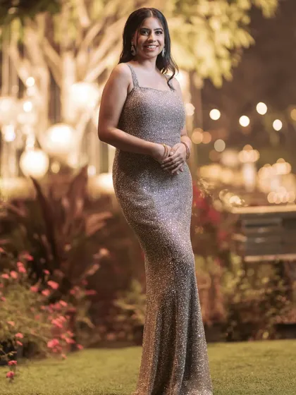 A clear, full-length portrait of the custom champagne gown. This view shows the flattering silhouette and the way the light catches the shimmering fabric, creating a truly elegant look.