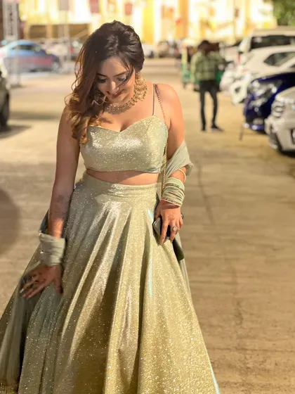 A candid shot looking down at the glittering lehenga. This shows a genuine appreciation for the outfit's beauty.