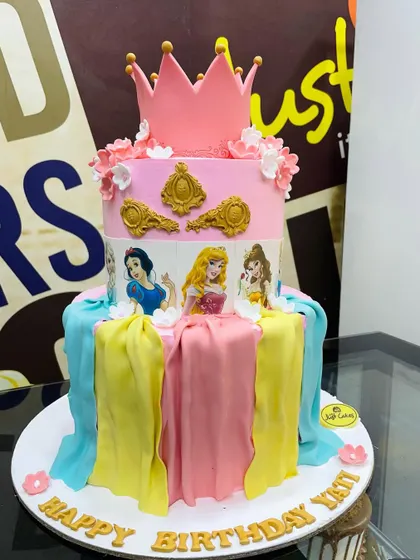 A cake fit for royalty, this 4kg Disney Princess design features edible images of Snow White, Aurora, and Belle. The tiers are decorated with fondant drapery in their signature colors and topped with a pink crown.