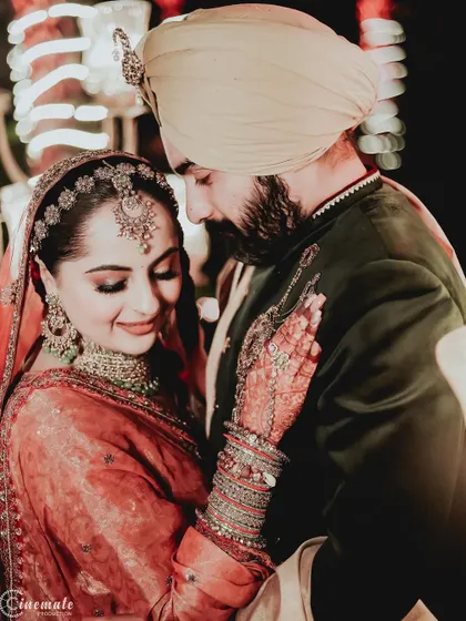 A close, intimate portrait of a Sikh couple on their wedding day. The warm lighting highlights their loving expressions and gorgeous traditional attire.
