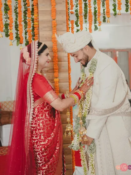 The Varmala ceremony, a playful and significant ritual. Aditya and Aditi share a smile as they exchange garlands.