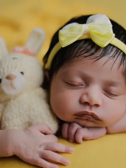 This classic pose is enhanced with a small, soft bunny prop for the baby to cuddle, adding a touch of sweetness.
