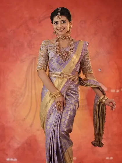A model showcasing a lavender silk saree with a fully embroidered blouse. This soft, elegant color is a beautiful choice for an engagement or reception.