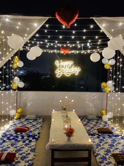 A beautiful terrace decoration for a birthday night. We used a large cabana frame with sheer curtains, fairy lights, and balloons to create an open-air dining experience.