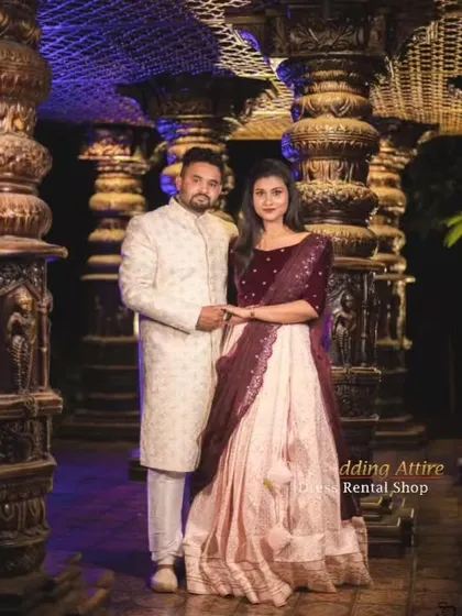 This couple demonstrates a regal and coordinated look with a velvet crop top and light pink skirt paired with a classic off-white sherwani. The contrast in textures between the velvet and the sherwani adds visual interest.