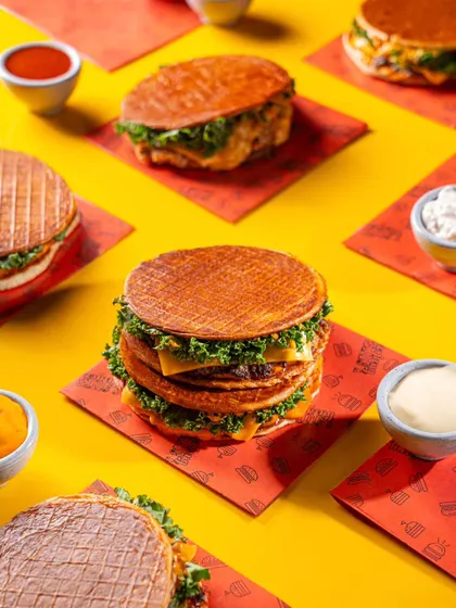 A stack of Louis Burger's unique pancake-style burgers, creating a fun and memorable image for the brand.