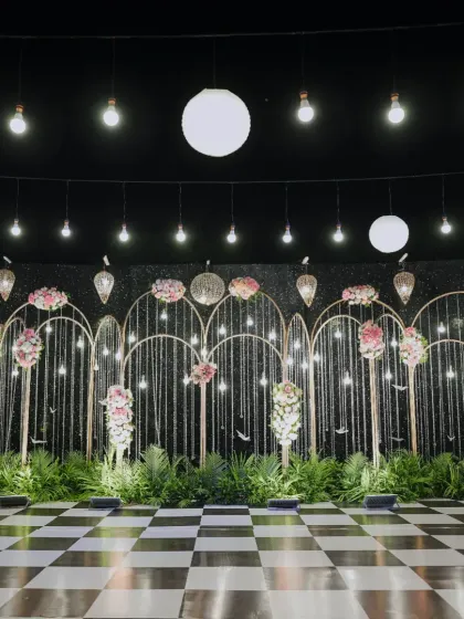 A "Starry Night" sangeet stage, featuring a checkered dance floor and a backdrop fatores of sparkling arches and floral details.
