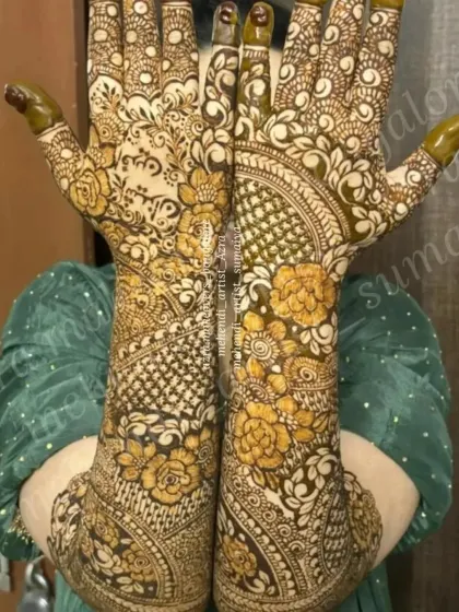 A close up view of a bride showcasing her full mehendi, with a unique reverse-fill floral design.