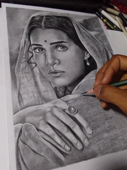 A graphite drawing of actress Kriti Sanon as Sita from the movie Aadipurush. My hand is in the shot, showing the final touches being added to her drapery.