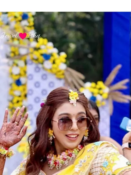 A close-up of the bride dancing, showing off her floral earrings and maang tikka. It's all about enjoying your special day to the fullest.