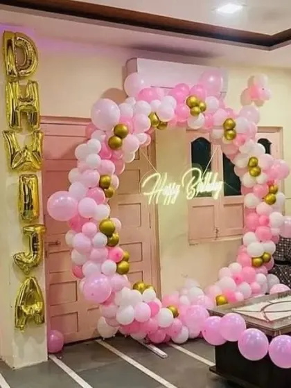 A pink and white balloon ring with gold accents, personalized with "DHWJA" in foil letters.