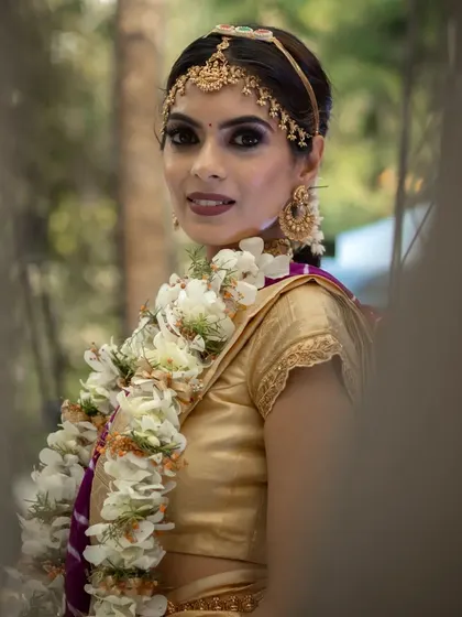 Here, the bride's Muhurtham makeup is designed to look flawless from every angle. The subtle base and defined eyes ensure she looks stunning in her wedding photos and videos.