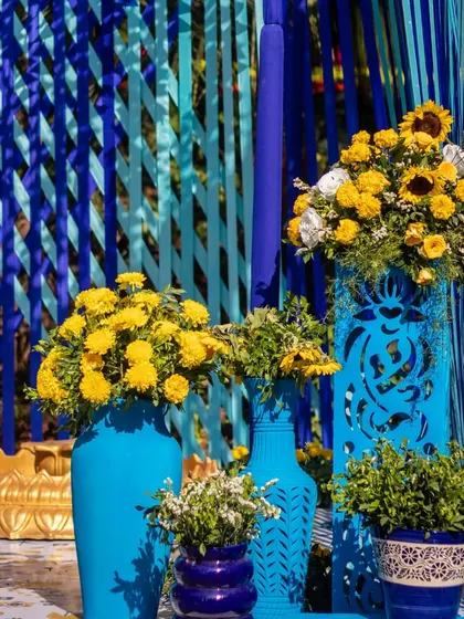 A vibrant floral arrangement in a blue vase, set against a backdrop of blue ribbon curtains, perfectly capturing the theme.