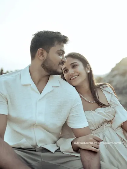 A sun-drenched pre-wedding portrait. The bright light and the couple's happy, loving expressions create a warm and joyful image.