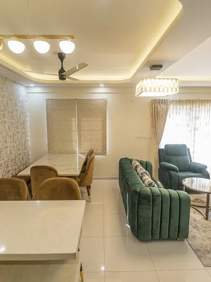 An overview of the open-concept living and dining space, where a modern chandelier and false ceiling design help to define the different functional zones while maintaining a cohesive look.