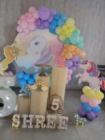 A side view of the unicorn party setup, showing the layered unicorn cutouts.