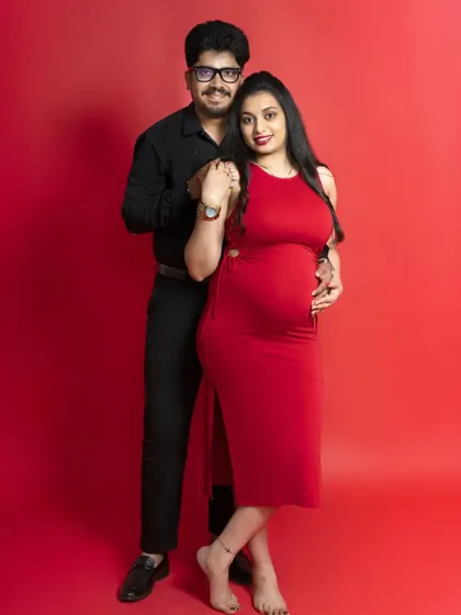 A classic couple's portrait against a red backdrop, full of love and anticipation. We guide our clients to feel comfortable and let their connection shine.