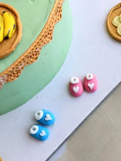 Tiny pink and blue baby shoes, handcrafted from fondant. These are a popular and adorable addition to baby shower and gender reveal cakes.
