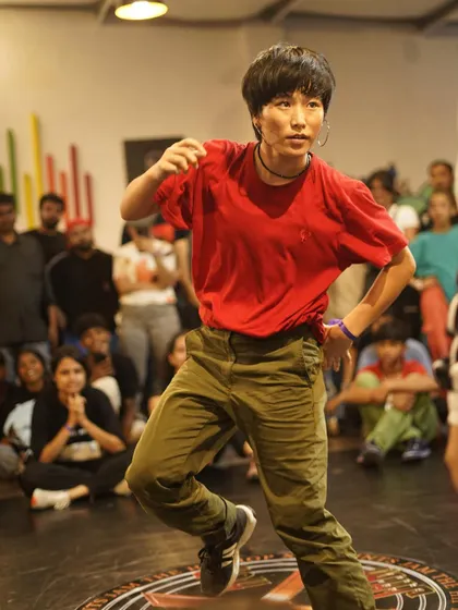 A b-girl competitor focused and ready during her round. The competitive spirit is strong across all categories at our jams.