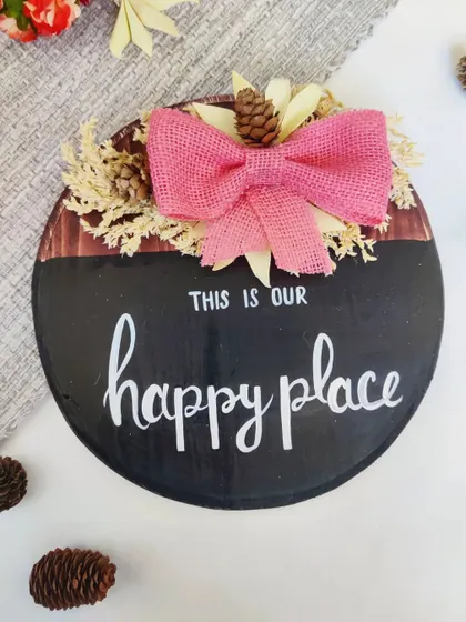 A cheerful "This is our happy place" sign, perfect for a family room or any space where you gather with loved ones.