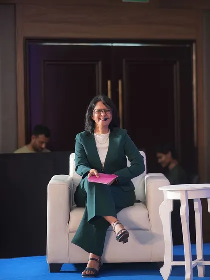 A photo of me sitting in a chair on stage. Words are the building blocks of our reality. Today, choose words that nourish your soul and reflect your awesomeness.