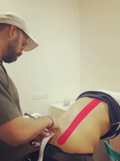 A close up of a therapist applying kinesio tape. We ensure our healing touch is available even for clients with emergency travel plans who need immediate support for their pain.