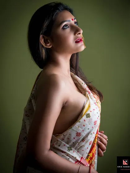 A powerful upward-looking pose from the 'Moksha' series. The lighting highlights the model's profile and the elegant drape of the saree, symbolizing a look towards spiritual freedom.