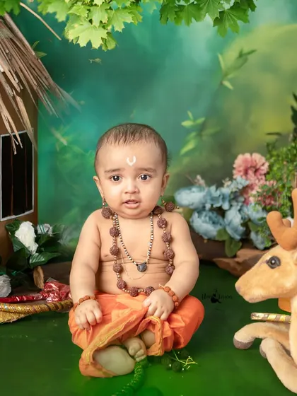 This baby boy looks so divine as little Lord Ram, sitting in a forest scene complete with a hut and a toy deer.