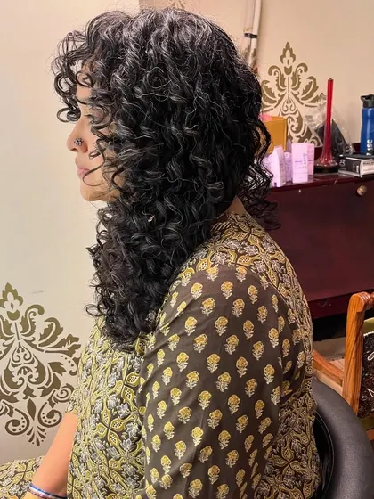 The side view highlights the volume and definition of her curls.