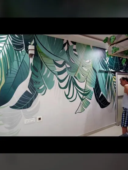 A tropical leaf mural brings a fresh, natural vibe into this room. The large green leaves create a feeling of being in a calm, green space, perfect for relaxing.