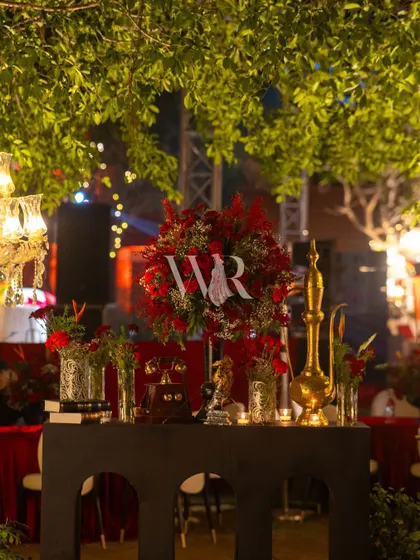 Vintage details for the Sufi night. We styled this console table with an antique telephone, a golden surahi, old books, and lush red roses to add layers of storytelling and nostalgia to the decor.