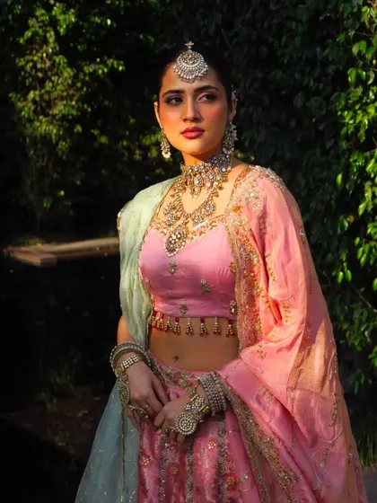 Elegance steeped in tradition. A beautiful pastel pink and mint green lehenga, styled with heavy, traditional jewelry for a unique fusion look.