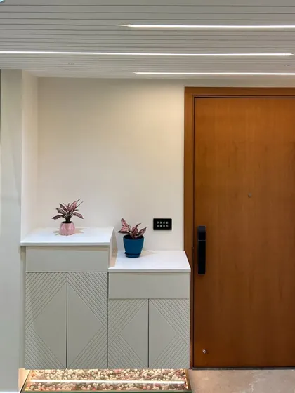 A clean and modern entryway featuring a smart door lock, a smart panel, and automated profile lights on the ceiling.