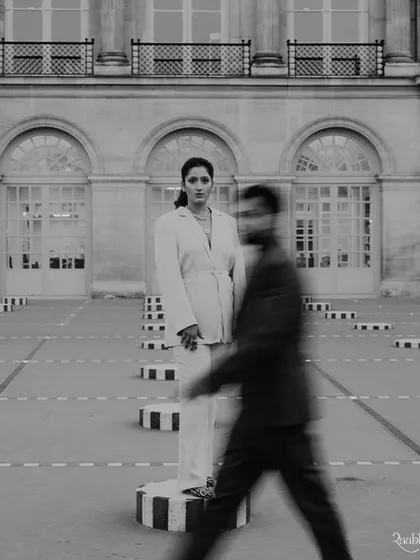 A black and white version of the Palais Royal shoot, using motion blur to create a dynamic contrast between the static architecture and the groom walking past.