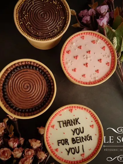 A collection of cake tubs showing the variety of designs possible. From simple swirls to personalized messages like "Thank you for being you," these make great gifts.