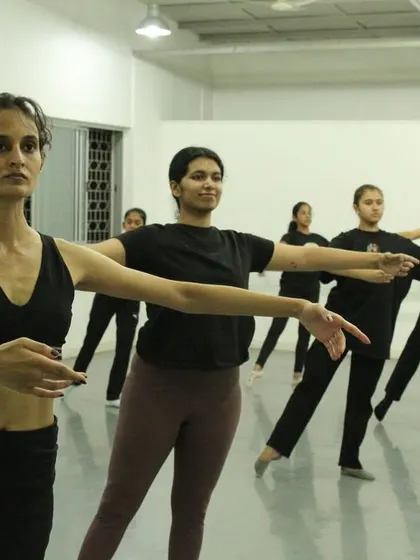 Dancers work on their alignment and arm positions at the barre. Even in contemporary and jazz, the fundamentals of posture and control are essential.