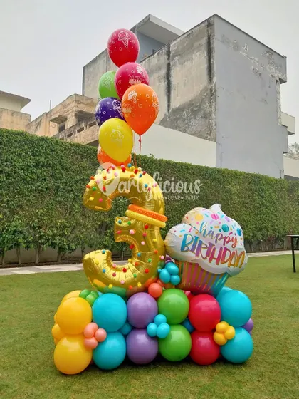 Turning 3 in style. This vibrant balloon bouquet for a 3rd birthday is bursting with color, confetti, and cupcake cheer.