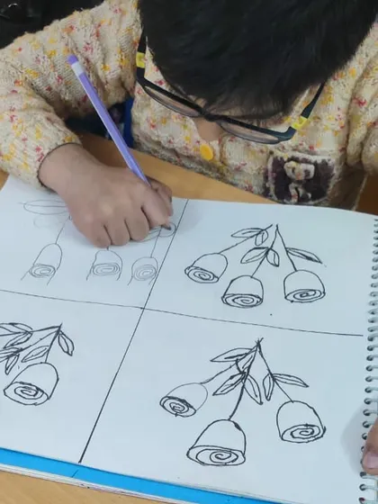 This worksheet shows how we teach drawing in a structured way. The student is practicing how to draw a rose step-by-step, from simple swirls to a complete flower.