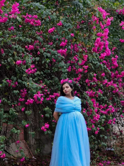 A serene moment captured in the light blue tulle gown, showing how it drapes elegantly for a classic maternity portrait.