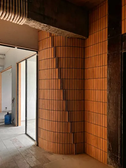 The corner detail of a curved brick wall in progress. This shows our exploration of how a simple material like brick can be used to create complex, flowing architectural forms.
