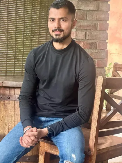 A relaxed, seated pose in a casual setting.