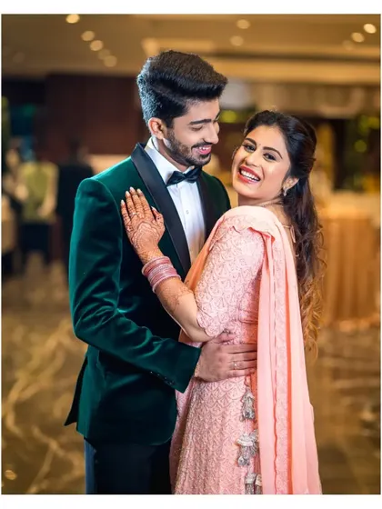A moment of pure, unrestrained happiness during a reception. The bride's joyful laugh and the couple's embrace say it all.
