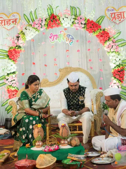 A shot of the couple seated with the priest during their engagement puja, capturing the solemnity and importance of the rituals.
