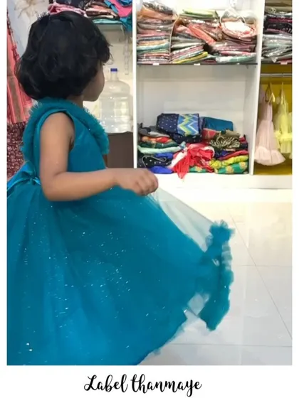 A side view of the blue frills frock, showing the full skirt.