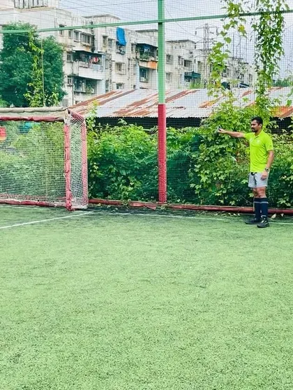 A coach directs players from the goal line, providing strategic guidance during a practice match. Our coaches are actively involved in every aspect of training.