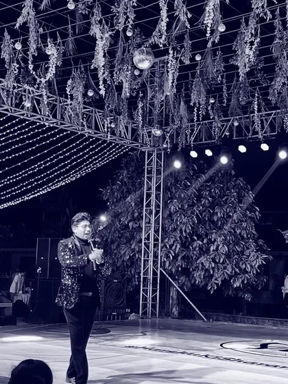 A solitary moment on stage, mic in hand. This artistic shot reflects the responsibility and the presence required to hold the attention of a large audience.