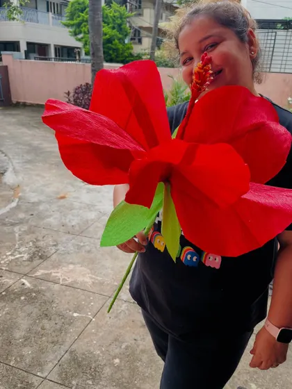 Here I am with a giant paper hibiscus we created. These large-scale paper flowers are perfect as photo props for events, unique party decor, or even as a statement piece for a wedding backdrop.